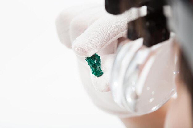 Photo master in magnifying glasses inspects dioptase