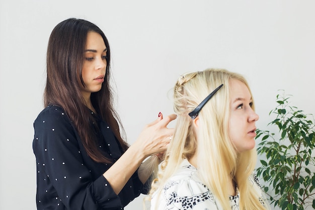 The master makes a hairstyle for a girl, beautiful curls