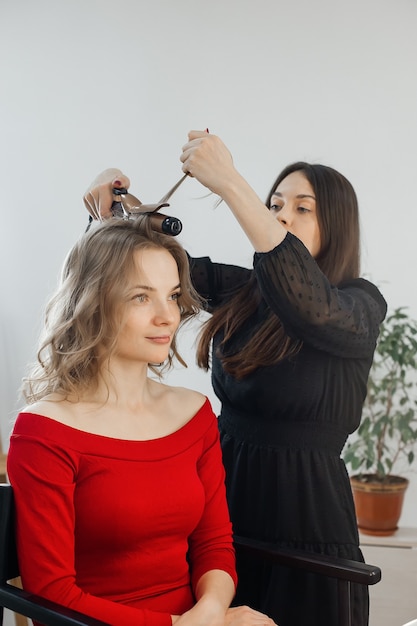 The master makes a hairstyle for a girl