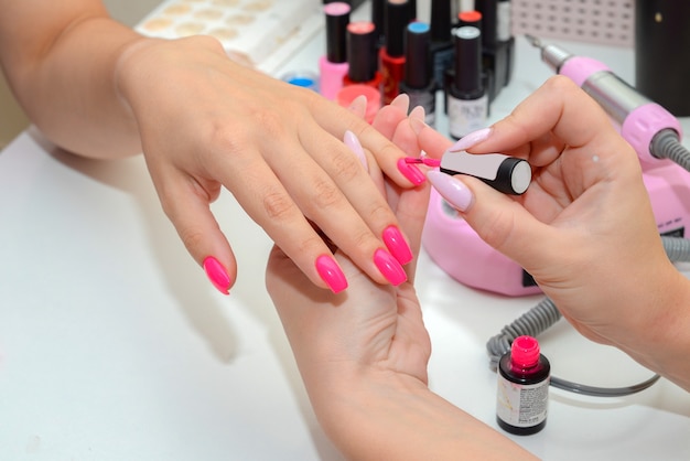 the master makes a manicure to the client in a saloon hands closeup