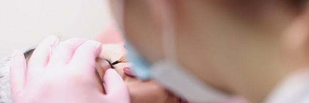 Master makes permanent makeup for eyelids of client in salon choice of permanent makeup