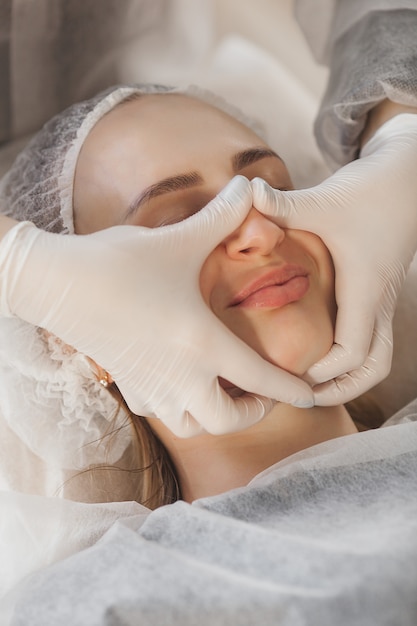 Master making a cosmetic procedure for her client. skin care treatment. woman making a face care procedure.