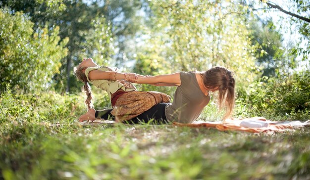 Master massage therapist performs a relaxing massage on the grass.