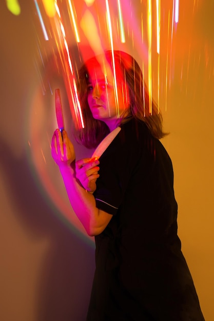 Master of the nail service and influencer blogger in a professional uniform with nail files in the hands poses at a creative photo