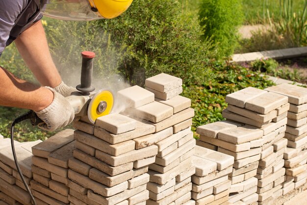 Master saws paving slabs with a grinder grinder