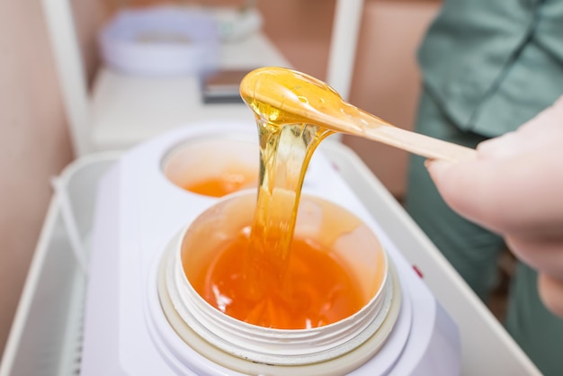 The master of sugar hair removal winds the epilation paste onto the Spatula.Close-up