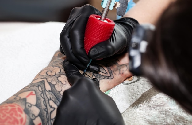 Master tattoo disegna la vernice arancione sul tatuaggio dei clienti