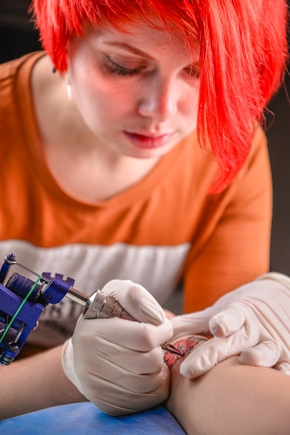 문신 살롱에서 문신을 만드는 마스터 tattooist. 문신 스튜디오에서 전문 문신 기계 장치에서 작업하는 전문 tattooer.