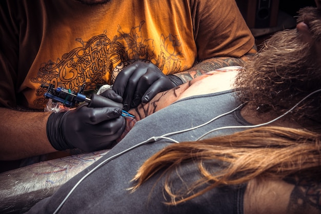 Master weergegeven: proces van het maken van een tatoeage in tattoo studio.