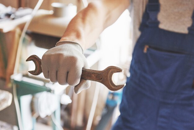 Master in forma di lavoro e guanti con una chiave in mano.