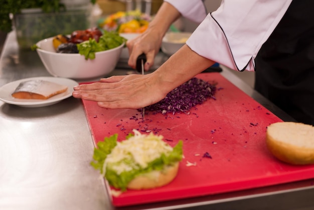 masterchef snijsalade voor een burger in de rastaurant keuken