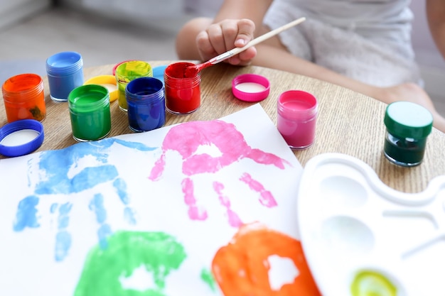 Masterclass voor kinderen in tekenen het kind maakt een handafdruk met verf