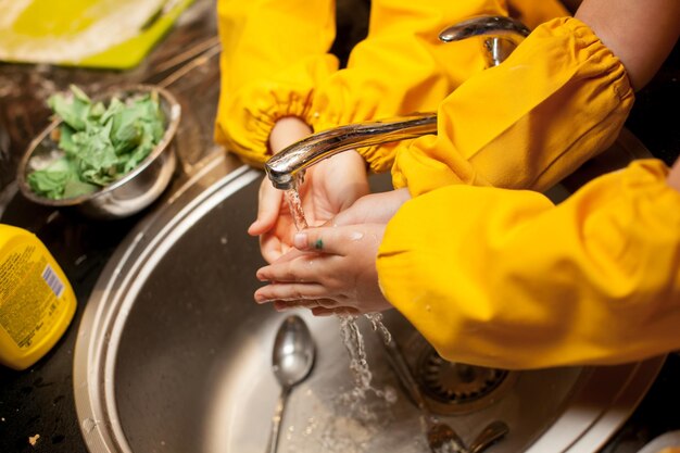 Foto masterclass voor kinderen over het koken van koekjes. het kind wast de handen in de wasbak voor het koken