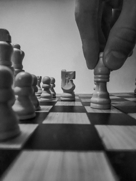 Photo masterful chess human hand skillfully holds bishop on chess board symbolizing strategy and tactics