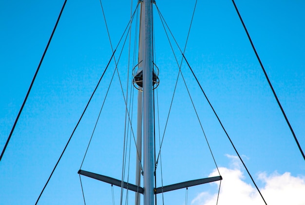 Photo masts of sailing yachts without sails with anchoring ropes view from below