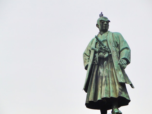 Statua di masujiro omura con il cielo nuvoloso come fondo.