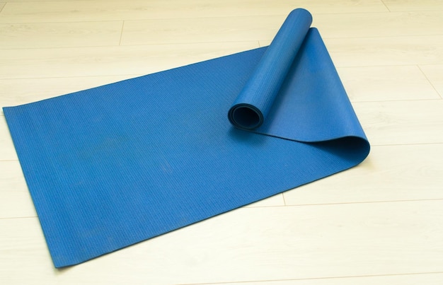 A mat for yoga and Pilates a phone with headphones and a bottle of water