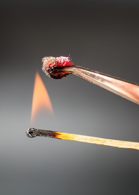성냥 불꽃은 실크 직물 샘플을 점화합니다.
