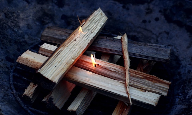 Match lighting the wood in the grill on fire