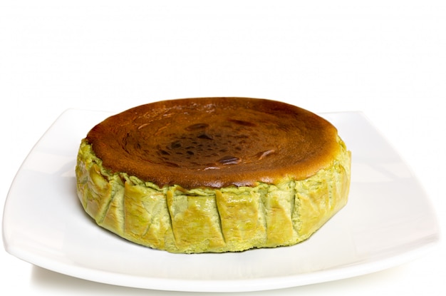 Cheesecake bruciato basco del tè verde di matcha isolato su fondo bianco.