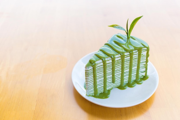 Matcha green tea crepe cake which on top with matcha sauce and decorated with fresh green tea leave