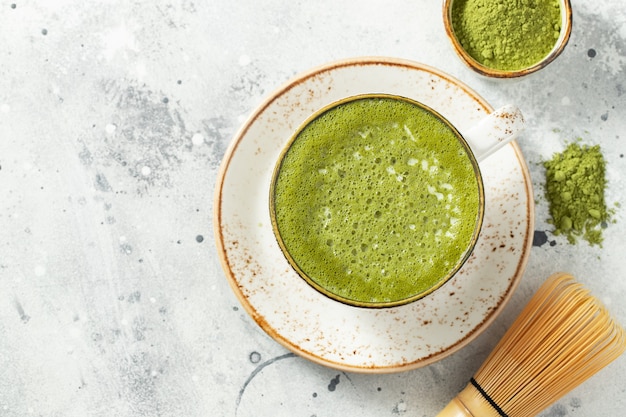 Tè verde matcha latte in una tazza con panna.