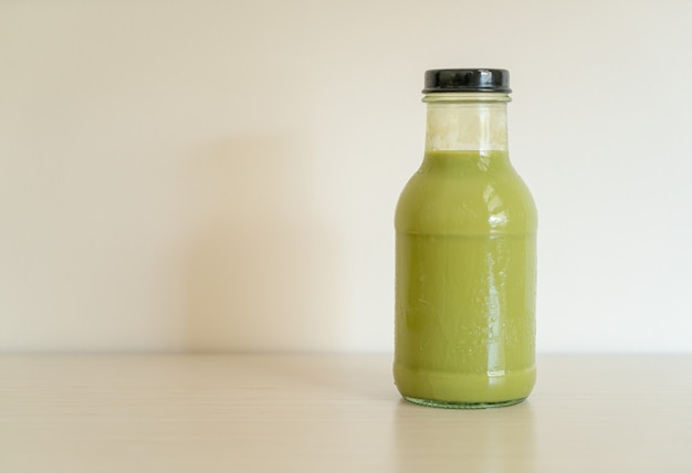 matcha green tea latte in glass bottle on the table