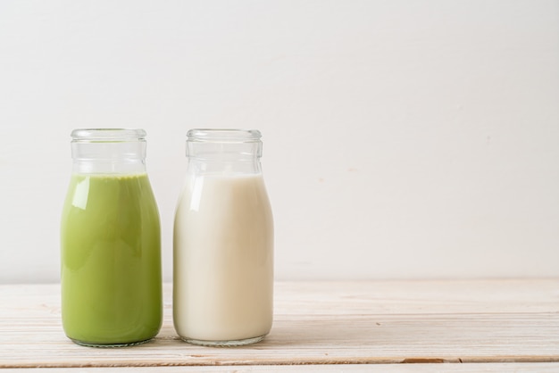 木の上の瓶に新鮮な牛乳と抹茶抹茶ラテ