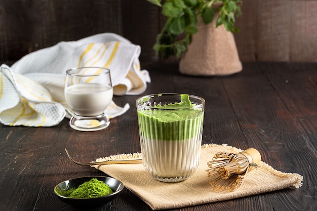 Matcha green tea latte with matcha powder and bamboo whisk