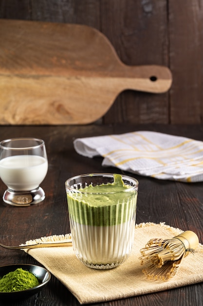 Matcha green tea latte with matcha powder and bamboo whisk