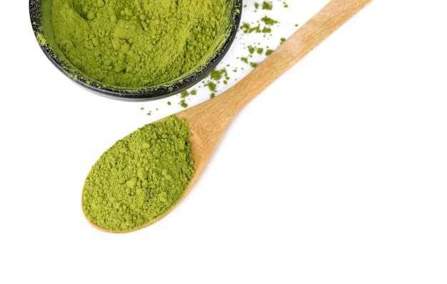 Tè verde matcha in polvere con cucchiaio di legno isolato su uno spazio bianco