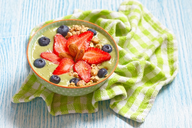 Matcha green tea smoothie with berries topping in a bowl