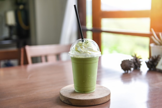 Matcha green tea with milk on plastic glass served in a cafe