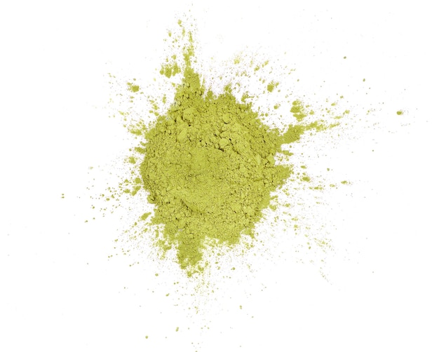 Matcha groene thee in poedervorm verspreid over witte achtergrond bovenaanzicht.