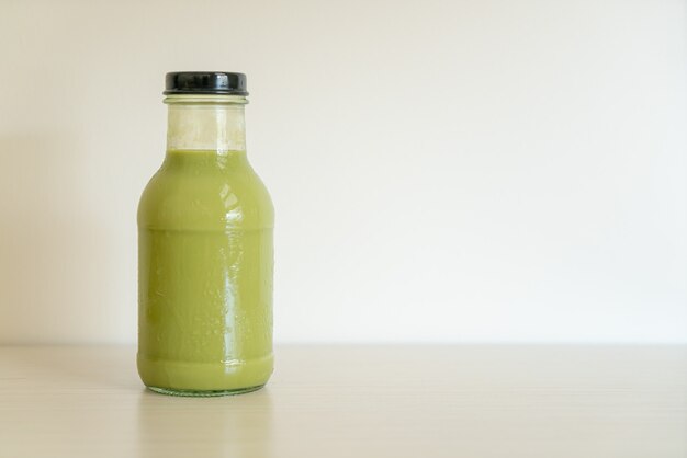 matcha groene thee latte in glazen fles op tafel