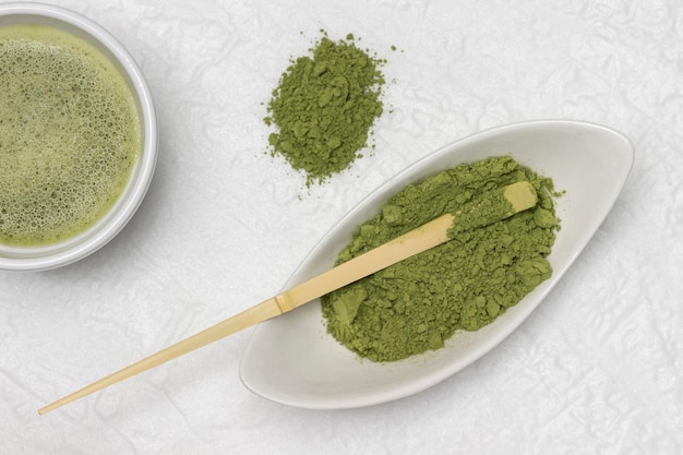 Matcha groene thee poeder en bamboe maatlepel in een kom Matcha thee in een kom