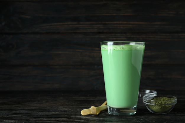 Matcha latte and accessories for making on wooden background