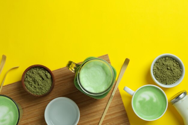 Matcha latte e accessori per fare su sfondo giallo