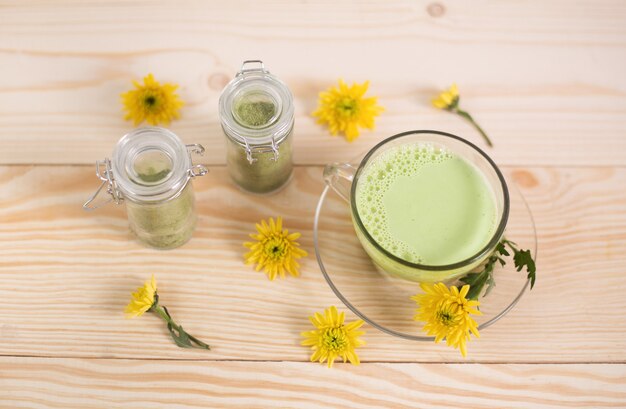 Matcha latte in a cup with matcha powder