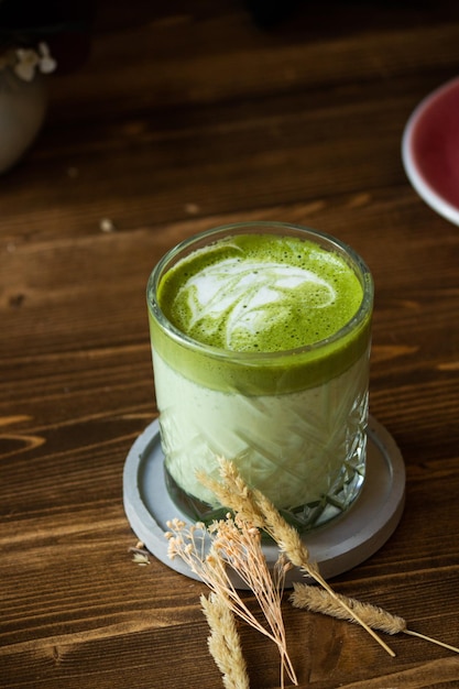 Photo matcha latte in glass with latte art