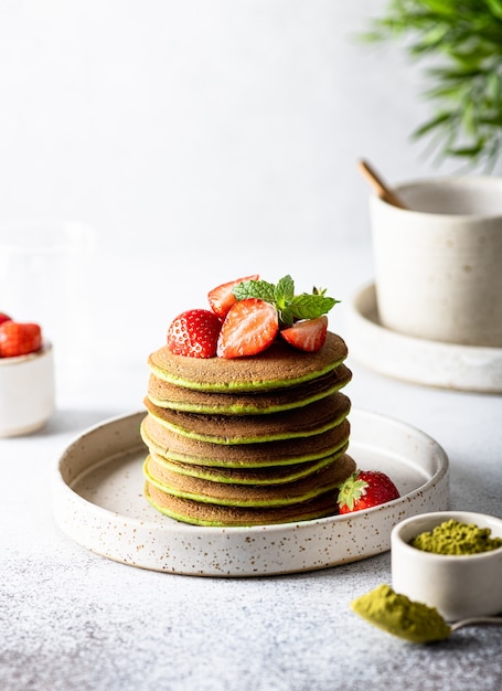 Matcha pancakes in a ceramic plate on a white surface