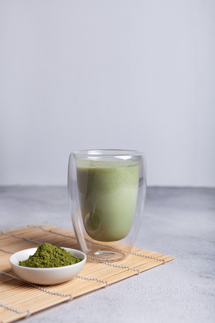 Matcha with milk in a glass on a light background
