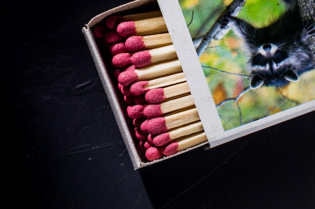 Matchbox with matches on the wooden background with copy space