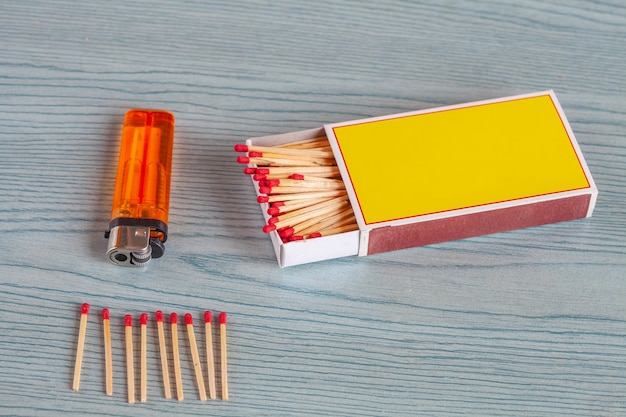 Matchstick and lighters on color wood table.