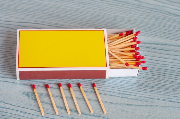 Matchstick out of matchbox on color wood table.