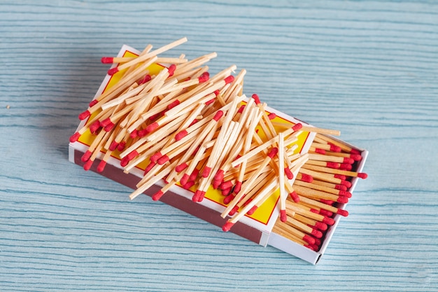 Matchstick out of matchbox on color wood table.