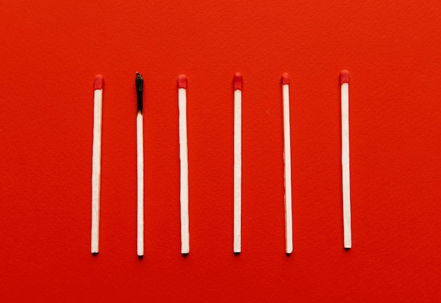 Photo matchsticks with one burned out on a red background