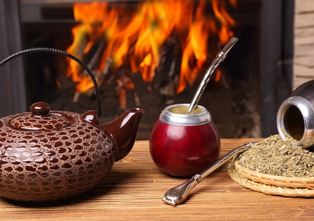 Foto mate nella zucca, bollitore, yerba sullo sfondo del fuoco