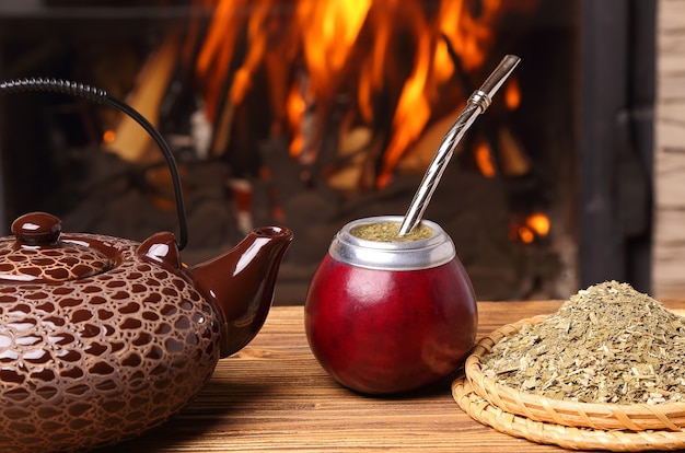 Mate in the calabash, kettle, yerba on fireplace background