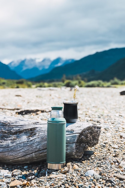 Mate en een thermoskan vol heet water klaar om te drinken in een natuurlijke omgeving latijnse drank